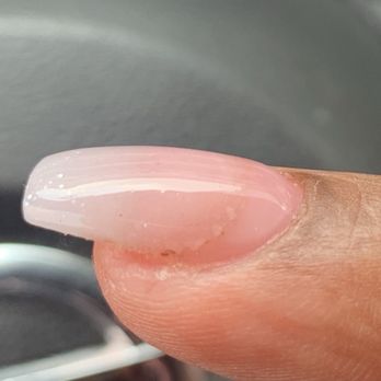 Custom Nails - She didn't file off enough old nail or brush off whatever was left behind from grinding away at the edges of the old nail. - Nail Salons Near Me - Pearland, Texas