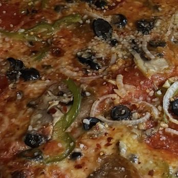 Cutty’s Pizza - The works close up with Parmesan and red peppers - Pizza Near Me Cutty’s Pizza - The works close up with Parmesan and red peppers - Pizza Near Me