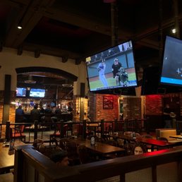 two televisions above a bar