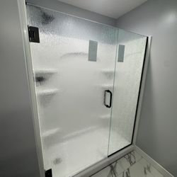 Norbert's Glass & Mirror - This is a custom frameless shower door and panel with rain pattern glass and matte black hardware.
