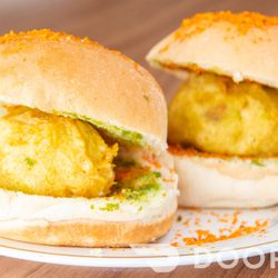 Bombay Chaat & Paan - Vada / Deep fried Potato dumpling placed inside a Bread Bun (Pav) - accompanied with Chutneys)