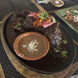 My Chamorro and refried beans side view. A must try if you like mole. Tasted like mole poblano. So tender too
