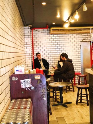 Photo of 2 Bros Pizza - New York, NY, US. Some seating in back