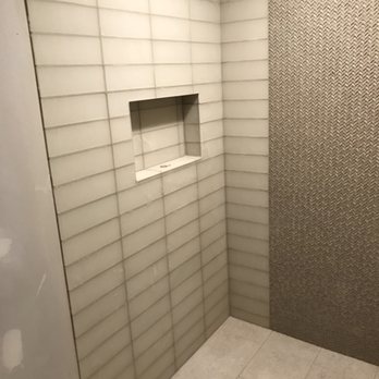 MGM Construction - Custom shower with glass tile/mosaic on walls and porcelain flooring with gutter drain. - Electricians Near Me