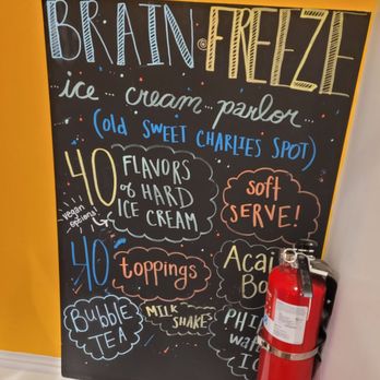Brain Freeze - a fire extinguisher next to a chalk board - A chalkboard menu at Brain Freeze ice cream parlor lists 40 flavors, toppings, and drinks with colorful handwritten text and decorative elements. - Ice Cream & Frozen Yogurt Near Me - Haddonfield, New Jersey