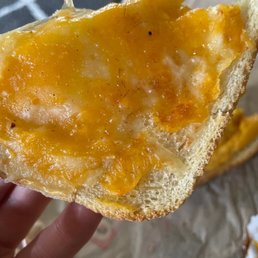 a piece of bread with cheese on it a piece of bread with cheese on it