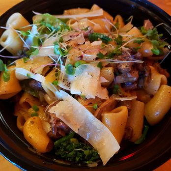M'tucci's Italian - Pasta special, beef tips, broccoli, mushrooms...delicious! - A pasta dish featuring large pasta shells topped with microgreens, cheese shavings, and vegetables. The dish appears to include beef tips, broccoli, and mushrooms, served in a black bowl on a wooden surface. The presentation emphasizes fresh ingredients and garnishes. - Italian Near Me - Albuquerque, New Mexico