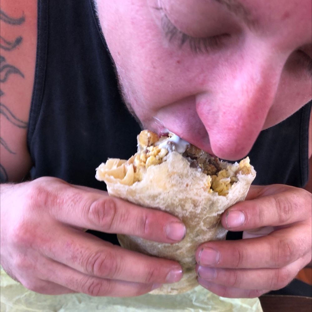 Jector's Burritos - a man eating a burrito - Mexican Near Me - Yuma, Arizona Jector's Burritos - a man eating a burrito - Mexican Near Me - Yuma, Arizona