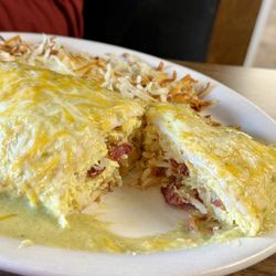 Smothered breakfast vaca burrito with green sauce and bacon.