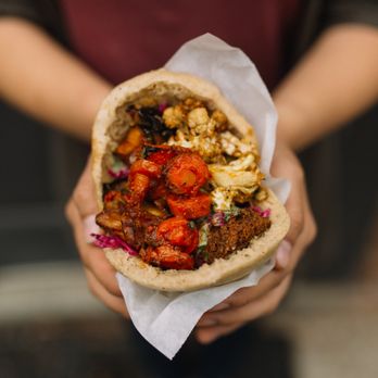 Brassica - a person holding a pita sandwich - Salad Near Me - Westlake, Ohio Brassica - a person holding a pita sandwich - Salad Near Me - Westlake, Ohio