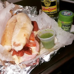 a sub sandwich and a cup of guacamole