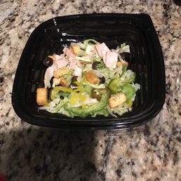 a salad in a plastic container on a marble countertop a salad in a plastic container on a marble countertop