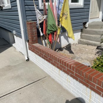 Envision Contractors - a row of flags hanging on a brick wall - General Contractors Near Me