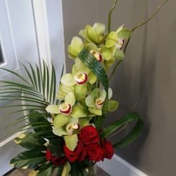 Gorgeous tropical flowers and foliages pair beautifully with classic red roses!