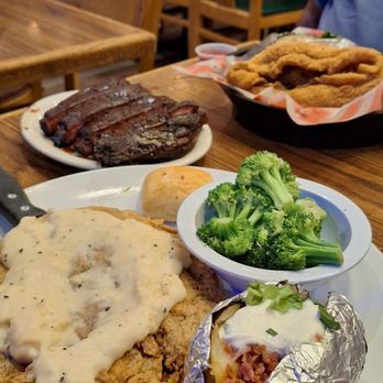 Flat Creek Restaurant - Chicken fried steak with broccoli and a baked potato. In back a side of ribs and a 3 way seafood basket. - Seafood Near Me - Cape Fair, Missouri