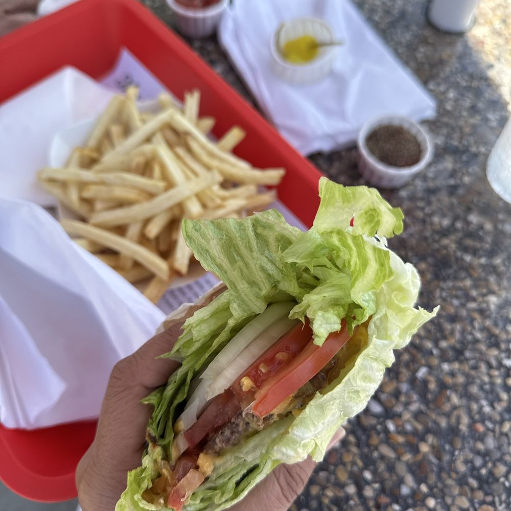 Protein style cheeseburger with grilled onions and raw onions, and french fries Protein style cheeseburger with grilled onions and raw onions, and french fries