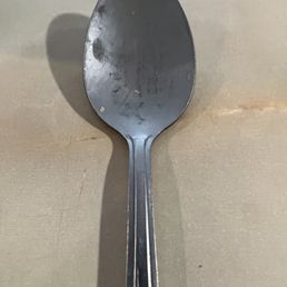 Dirty spoon among the unclean table service placed on napkins and waiting at the table upon arrival.