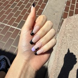 Black French tip with lavender accent nail and flower charms Black French tip with lavender accent nail and flower charms