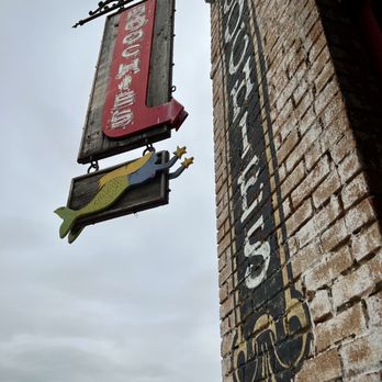 Hoochies - a brick building with a sign hanging from the side - Seafood Near Me - Denton, Texas