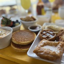 Up For Brunch - Shrimp and grits, beignet, chicken waffle and over easy eggs. Seriously hardy breakfast.