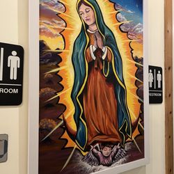 Virgen de Guadalupe art piece near restrooms