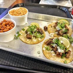 American Taco Company - Three street tacos plate with pinto beans and rice.