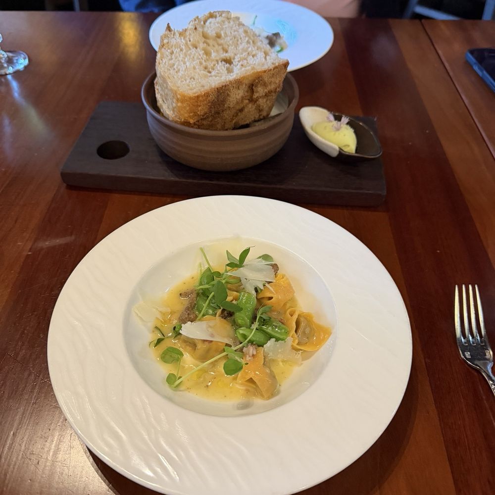 Altura - Pasta wagyu ravioli with sweet greens in a cheesy sauce and sourdough bread with seasoned butter. - Italian Near Me - Seattle, Washington