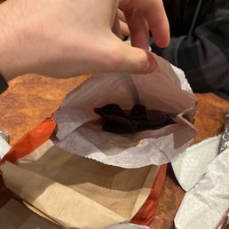 a person grabbing a piece of food out of a bag a person grabbing a piece of food out of a bag