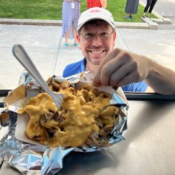 Times Square Catering Food Truck - Fresh pulled pork with curly fries and melted cheddar cheese. Happy person.