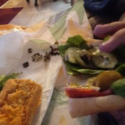 This photo is my boyfriend picking olives off his sandwhich after we tries to tell the sandwhich maker to not put olives on the sandwhich.