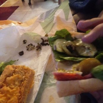 Subway - This photo is my boyfriend picking olives off his sandwhich after we tries to tell the sandwhich maker to not put olives on the sandwhich. - Fast Food Near Me - Glendale, Arizona
