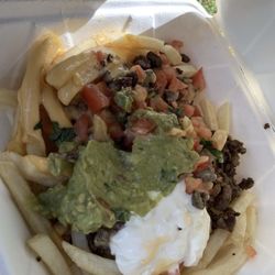 Asada Fries with nacho cheese, guacamole, beans, and sour cream.