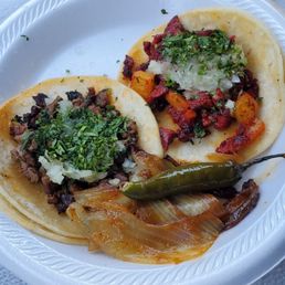 Asada taco and al pastor taco with grilled onion and serrano pepper