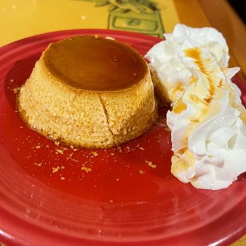 Mariscos Altamar - House made Flan was creamy and delicious - A creamy caramel flan with a smooth top and cracked edges is served on a red plate, accompanied by whipped cream drizzled with caramel sauce. - Mexican Near Me - Albuquerque, New Mexico