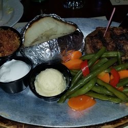 Bacon wrapped Filet Mignon with a side of veggies and a baked potatoe with everything.