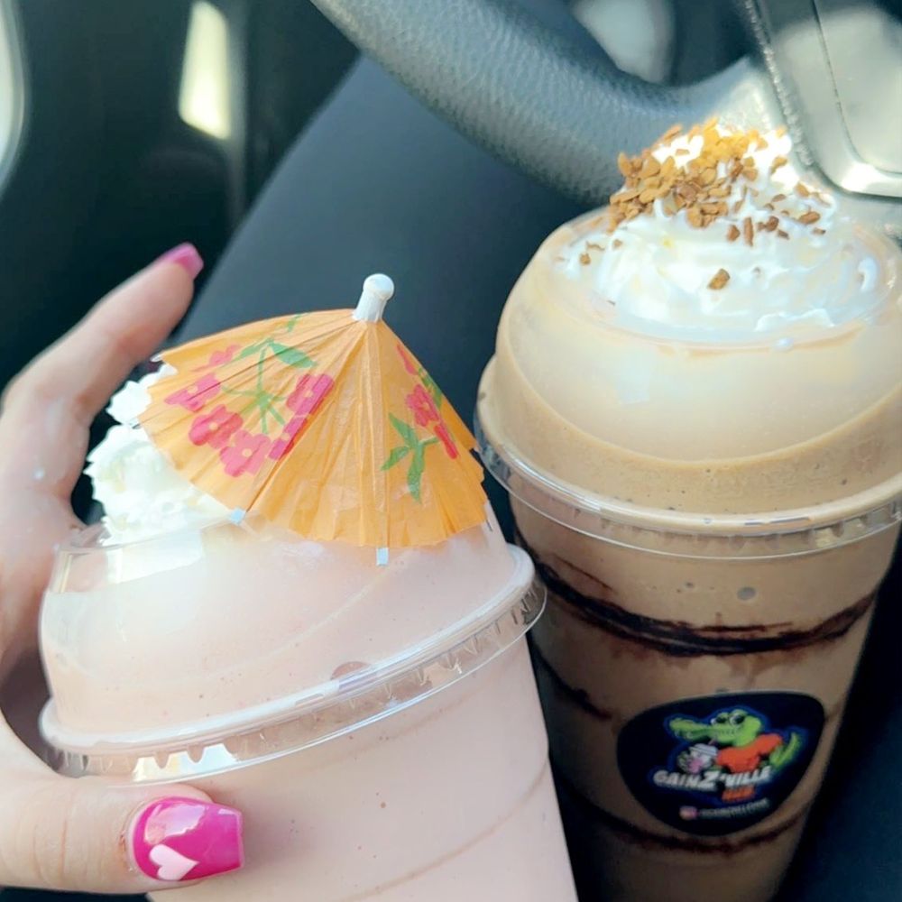 a hand holding a cup of coffee and a drink a hand holding a cup of coffee and a drink