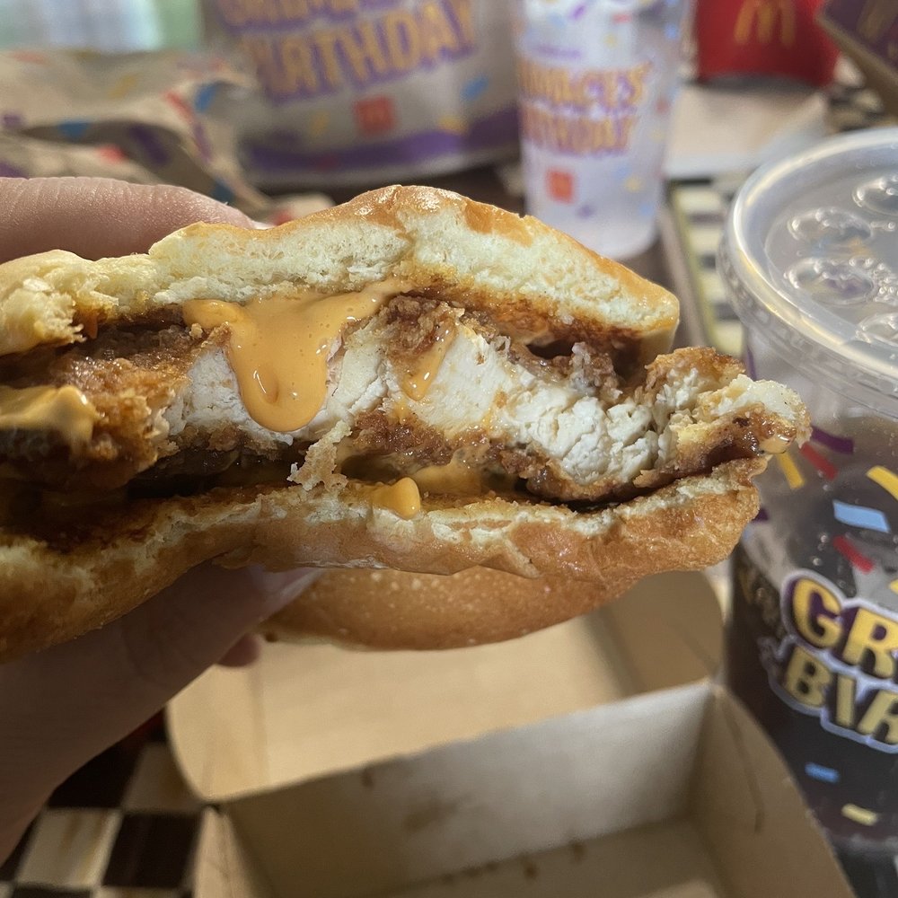 McDonald's - a hand holding a half eaten sandwich - Burgers Near Me - Brookfield, Connecticut