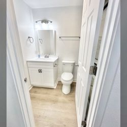 Monroe bathroom remodel features white vanity and LVP floor install.