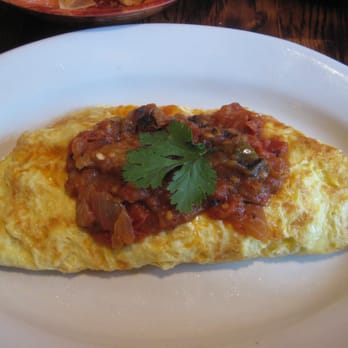 El Centro - Mexican Omelet (stuffed with bacon, cheese, and poblano pepper immersed in salsa tatemada, refried beans and avocado) - Mexican Near Me - Boston, Massachusetts