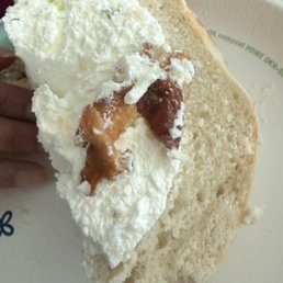 One of the bacon pieces in the bagel with cream cheese One of the bacon pieces in the bagel with cream cheese