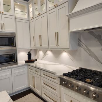 Lorenzo Remodeling - a kitchen with white cabinets and marble countertops - Painters Near Me - Houston, Texas Lorenzo Remodeling - a kitchen with white cabinets and marble countertops - Painters Near Me - Houston, Texas