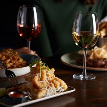 Milestones - a woman eating a meal with a glass of wine - Bars Near Me - Calgary, Alberta Milestones - a woman eating a meal with a glass of wine - Bars Near Me - Calgary, Alberta