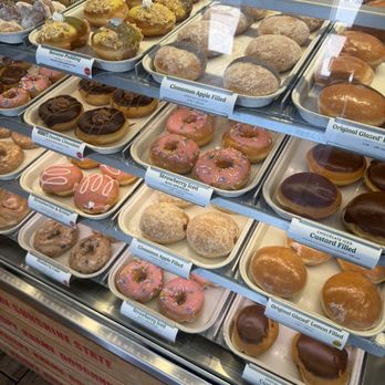 Krispy Kreme - Fresh donut display case with original glazed, strawberry iced, chocolate iced, and cinnamon apple filled. - Donuts Near Me - Kissimmee, Florida Krispy Kreme - Fresh donut display case with original glazed, strawberry iced, chocolate iced, and cinnamon apple filled. - Donuts Near Me - Kissimmee, Florida