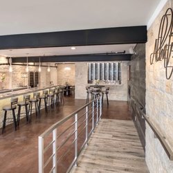 Empty tasting room, vineyard, family, historic photos play on monitor