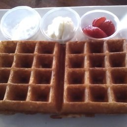 Half size waffle with powdered sugar, butter and small portion of Strawberries.