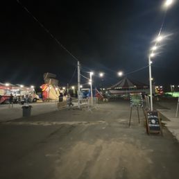 One truck vendor and 3 closed jump houses and an empty canopy.