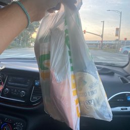 a person holding a plastic bag in the passenger seat of a car a person holding a plastic bag in the passenger seat of a car