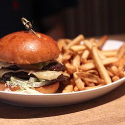 Banff Social - Alberta Bison Burger ($29) - Merlot caramelized onions, tomato mustard jam, smoked aged gouda, house made pickles, brioche bun