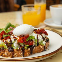 Cafe Americano - Avocado Burrata Toast, with Sundried Tomatoes and Dressing.