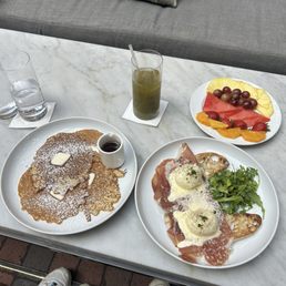 Fruit, green drink, pancakes, eggs benedict Fruit, green drink, pancakes, eggs benedict